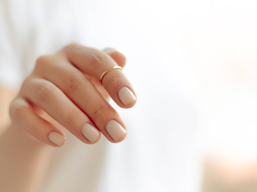 persons hand with white manicure