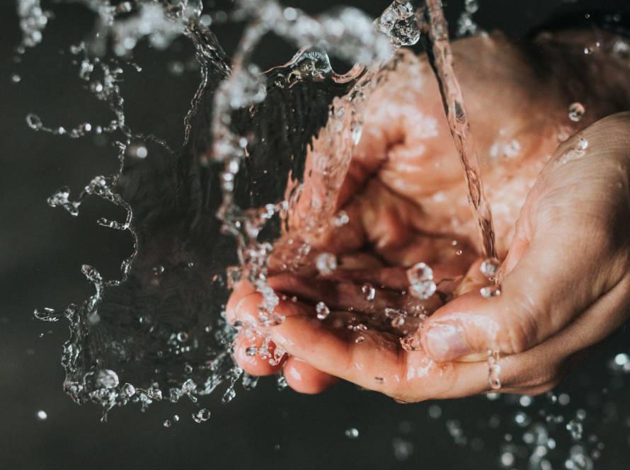 a person holding their hands under a stream of water
